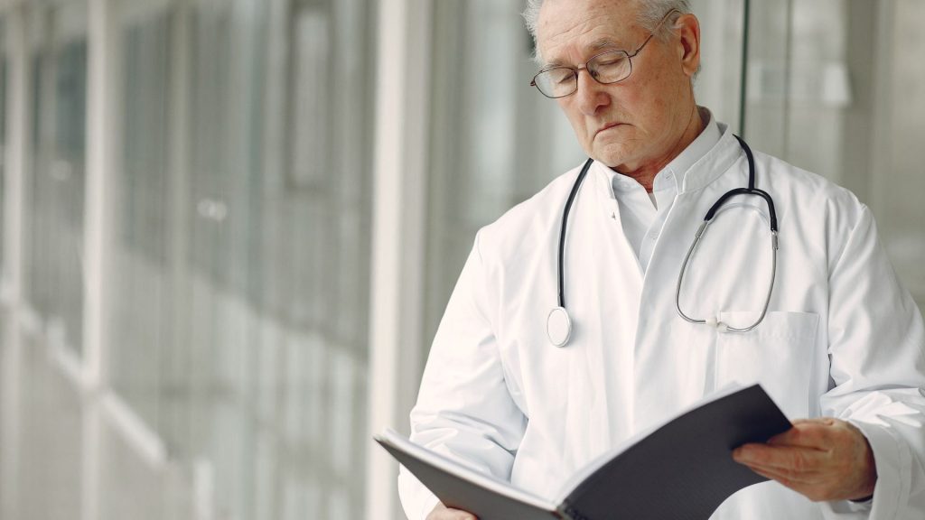 A senior physician reviewing research notes, reflecting evidence-based gastroenterology